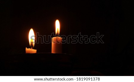 two burning candles, the candle light was red