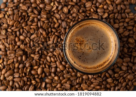 Top view of hot coffee cup and blurred coffee beans. Royalty-Free Stock Photo #1819094882