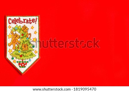 Christmas background with embroidered new year flag on red background, holiday, new year and Christmas concept. holiday. cats on the Christmas tree, a fun holiday picture