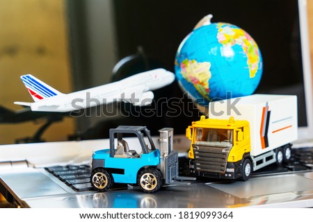 Logistics and supply chain management for online shopping concept: globe, white yellow truck, airplane, forklift on a laptop computer, depicts the delivery of goods or products.