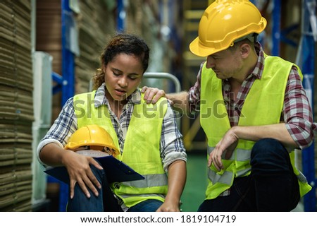 Young African female warehouse worker staff feeling sad and stress while Caucasian man consoling and encouraging due to been fired from job cause by company bankruptcy from coronavirus pandemic. Royalty-Free Stock Photo #1819104719