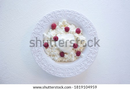 Cheese cottage with raspberries in bowl, top view stock photo