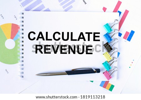 Notepad with text Calculate Revenue, paper clips, blue pen on financial diagrams. Business concept