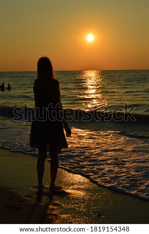 Woman looking at sea sunset.