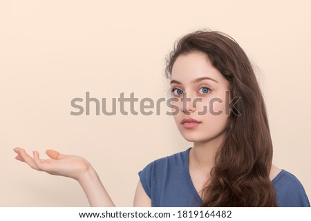 Woman holds her right hand horizontally, palm up.