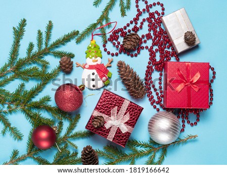 Christmas tree branches, snowman New Year's gifts, pine cones, the concept of meeting the New Year and Christmas. copy space, flat lay.