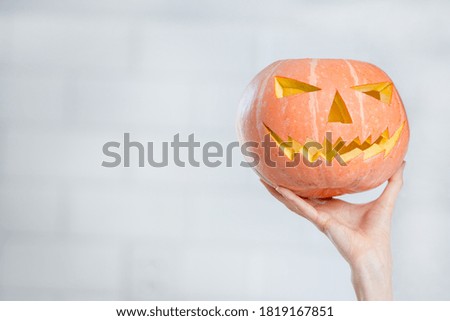 pumpkin in a hand over white kitchen