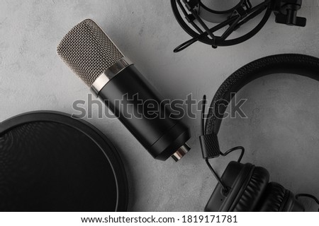 The lying professional microphone with headphones isolated on gary background. Recording studio. Music concept.