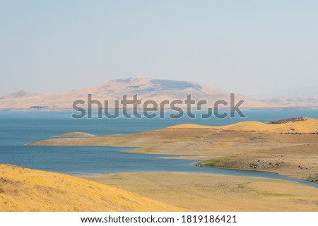 The San Luis Reservoir during dry and hot season, artificial lake on San Luis Creek in the eastern slopes of the Diablo Range of Merced County, California. USA Royalty-Free Stock Photo #1819186421