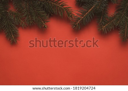 christmas spruce top border backdrop. evergreen decoration over red moody background. christmas and happy new year conceptual.