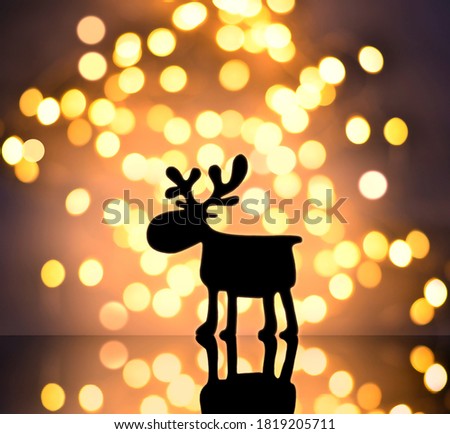 Magic christmas gold background with christmas lights and silhouette deer at night.