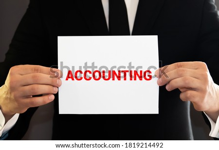 ACCOUNTING word inscription on a yellow folder with calculator and pen on unfocused foreground. white glossy background. Accounting and business concept