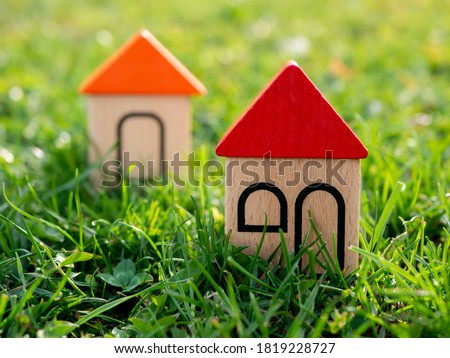 Colourful houses from wooden toy blocks on the green grass field.
