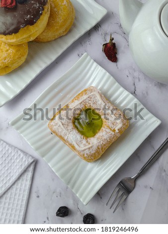 Donuts with glaze served on white plate , view on top, blurry