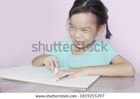 Cute girl smiling Beautiful eyes and doing art painting activities wearing green clothes. Pink background