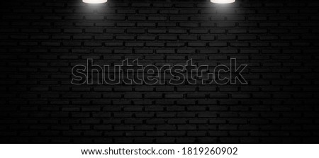 Empty brick wall of dark room with lighting from spotlight, workspace for product display and advertise on social media.