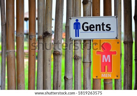 Toilet sign on bamboo wall over paddy field. Gentleman water closet (WC) symbol .