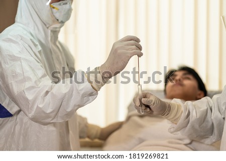 Hospital staff (doctor, nurse) in PPE suit take Covid 19 patient to do SWAB test. Healthcare concept for hospital, clinic after Covid 19 pandemic outbreak