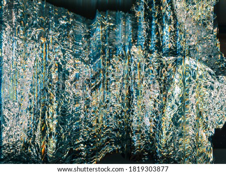 Iridescent metallic background. Glitched foil design. Shiny silver yellow crushed texture.