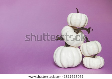 Happy Halloween composition. pyramid of white pumpkins on purple background, free space for text