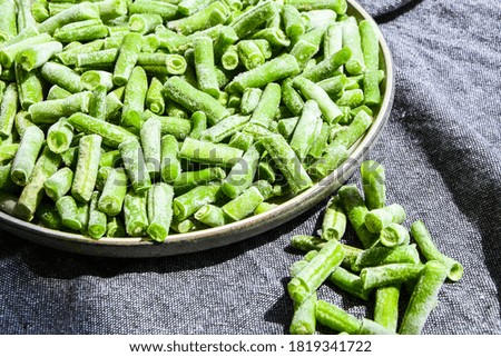 Fresh frozen green beans in a plate. Stocking up vegetables for winter storage. Healthy nutrition. Frozen beans vitamins
