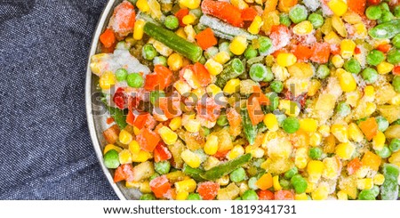 Mixed frozen vegetables in a plate. Stocking up vegetables for winter storage. Assortment of frozen vegetables