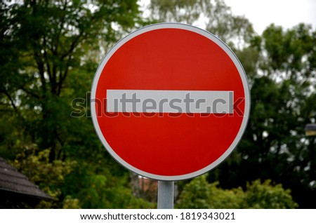 vertical metal repair signs commanded direction of travel, one way, no entry, pedestrian zone, respirator mask dead end street in detail in the background trees