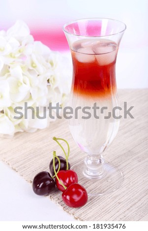 Glass of cocktail on table on light background