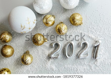 Happy New Year 2021. Silver digits 2021 with christmas hat are on white background. Holiday Party Decoration or postcard concept with top view and copy space.