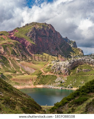 Lake, hiking track and clouds vertical composition in Somiedo, Asturias