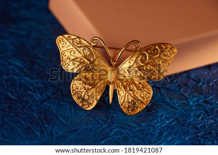 Stylish gold butterfly ornament on blue background