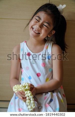 Girl hand holding a flower garland with jasmine