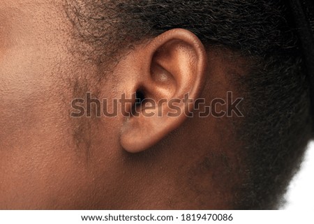 hearing, health and beauty concept - close up of african american woman's ear Royalty-Free Stock Photo #1819470086