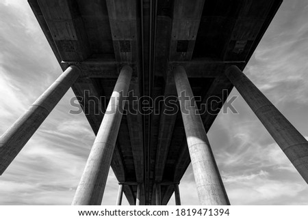 German “Autobahn“ or Motorway Bridge over the river Lahn near Limburg in Hessen Germany with tall concrete pylons from frog perspective black and white on a sunny day