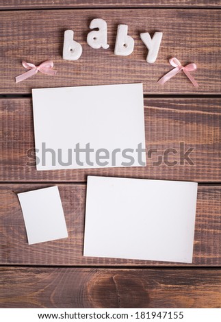 word baby and white frame photo on wood background