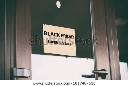The wooden sign with text Sale Black friday hanging on the door in the store