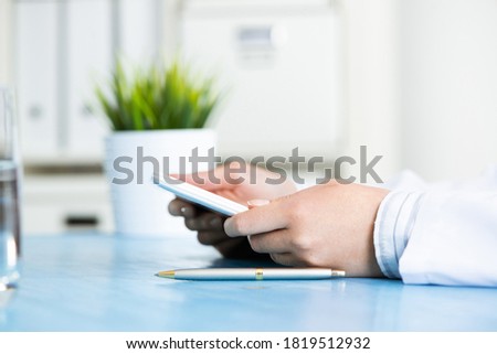 Close up of doctor hands with tablet computer. Therapist in white medical coat working with computer in office at desk. Professional diagnosis and treatment. Digital technology in modern healthcare.