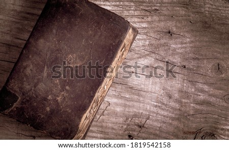 Weathered ancient book with leather cover on wooden table. Top view, copy space for text.