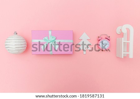 Simply minimal composition winter objects ornament sled fir tree ball gift box isolated pink pastel background. Christmas New Year december time for celebration concept. Flat lay top view copy space