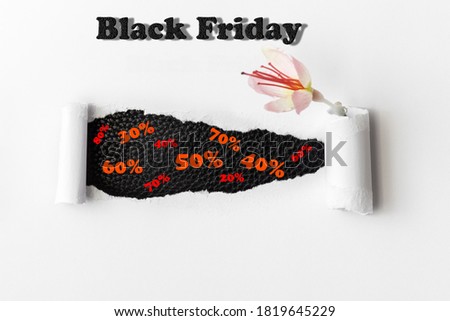 Black Friday. Sale. Black Hole in a white sheet of paper. Pink Flower. White Background.