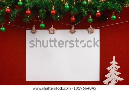 Christmas layout with white blank lettering sheet on red fabric background with Christmas decorations and toy tree