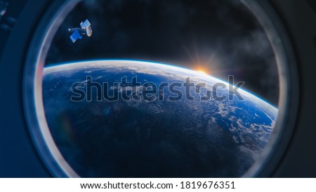 Breathtaking View of the Planet Earth as Seen from the International Space Station Porthole. Rising Sun Illuminates Our Blue Planet and Satellite Flying by. Scientifically Accurate 3D VFX Rendering Royalty-Free Stock Photo #1819676351