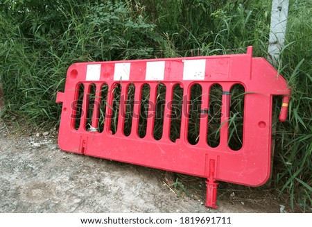 Damaged plastic road barrier Was left in the forest by the road after work.