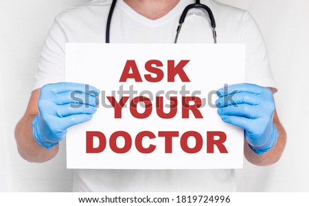 Closeup doctor hands holding white card sign with Ask your Doctor text message isolated on on white background. Healthcare concept. Medicine doctor hand working