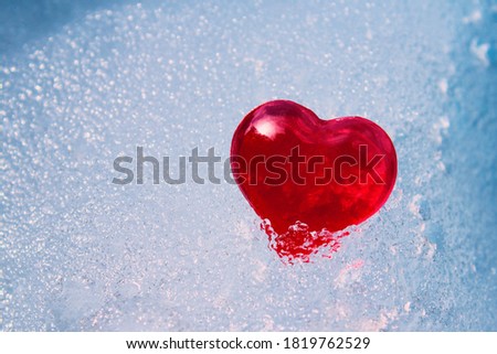 Red heart in ice. Close-up. Selective focus. Background. Texture.