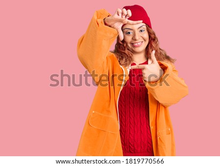Young latin woman wearing winter casual clothes smiling making frame with hands and fingers with happy face. creativity and photography concept. 