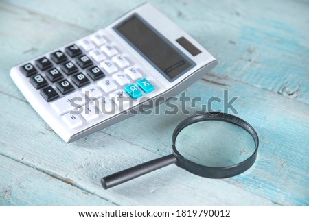 calculator and magnifier on the wooden table