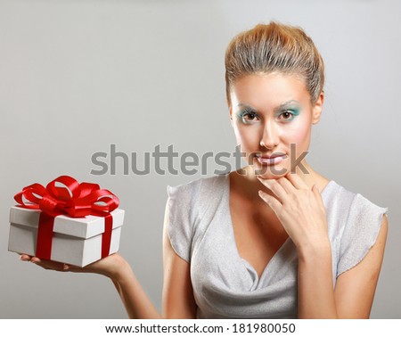 Girl opening x-mass present isolated on grey background