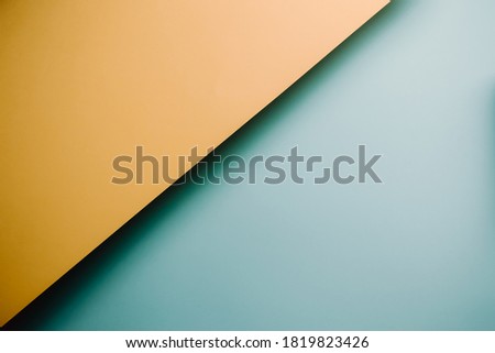 A yellow and blue pastel flat lay background with sharp layers and shadows with copy space