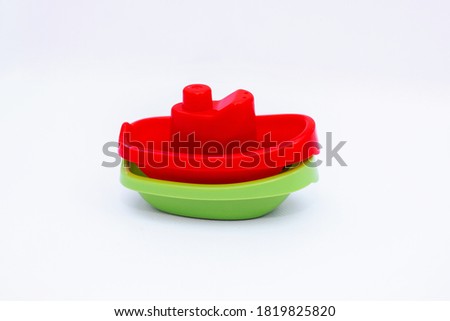 Games with children in the bathroom, red and green boats. Toy for children.